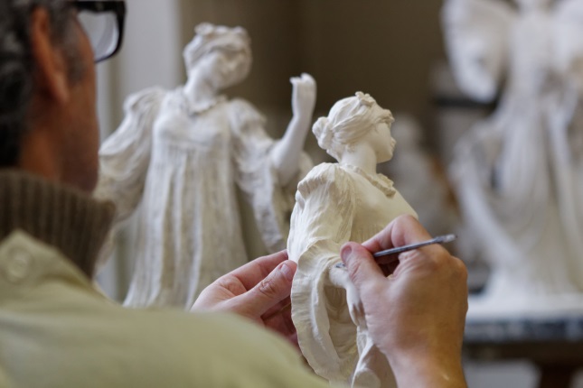 image of a sculptor in an advanced sculpture class adding detail