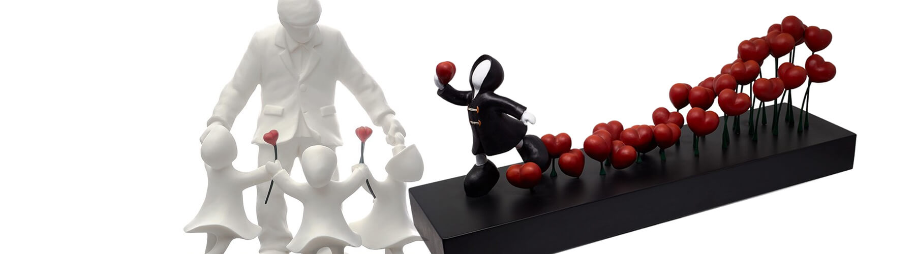 two sculptures, in black & white, featuring bright red hearts and featureless figures